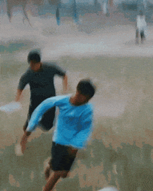 a blurry picture of a man in a blue shirt playing soccer