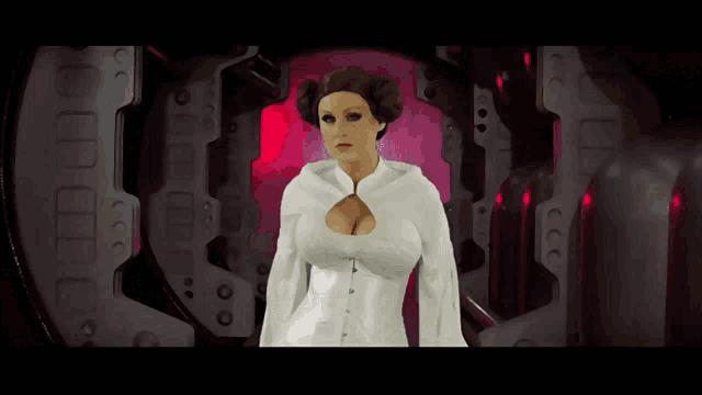 a woman in a white dress with a large breast is standing in a dark room
