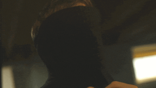 a close up of a man 's face with a turtleneck on