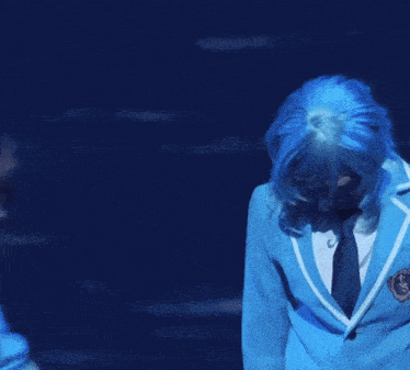 two people in blue uniforms are dancing on a stage .