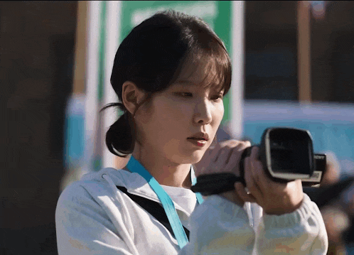 a woman is holding a camera in her right hand