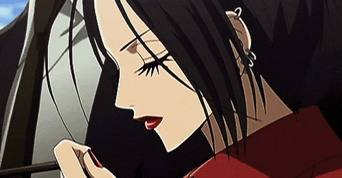 a close up of a woman 's face with black hair and red lips .