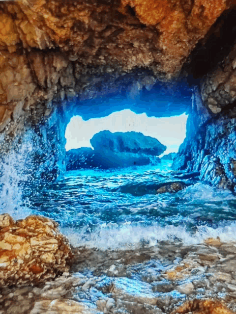 a cave with a view of a blue ocean