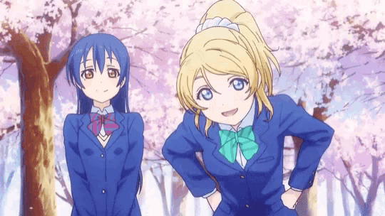 a couple of anime girls standing next to each other with their hands on their hips .