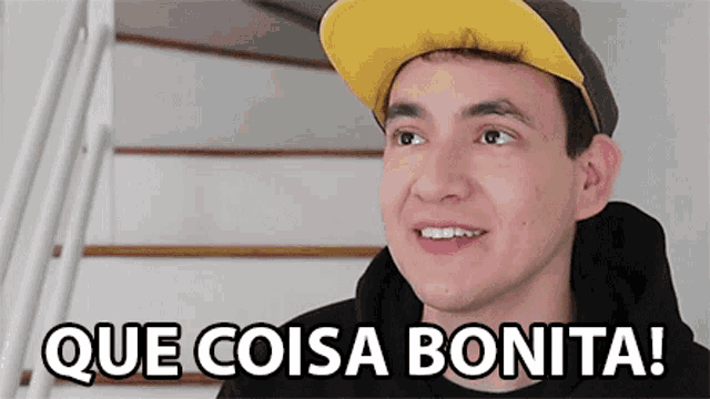 a young man wearing a hat says que coisa bonita on the screen
