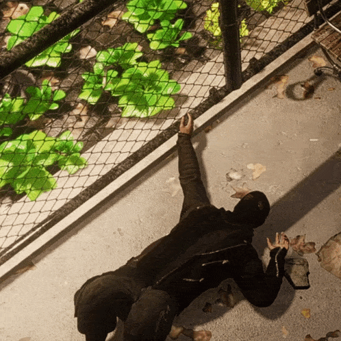 a person laying on the ground with a fence in the background