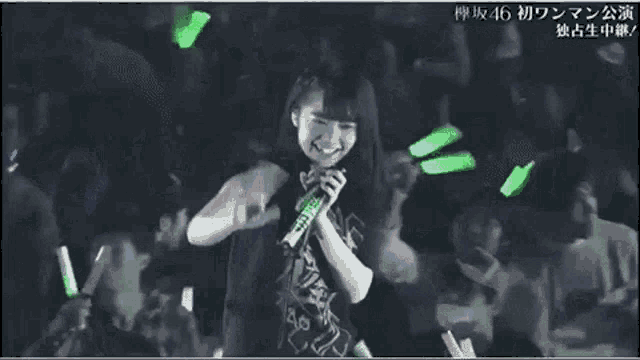 a girl is singing into a microphone in front of a crowd