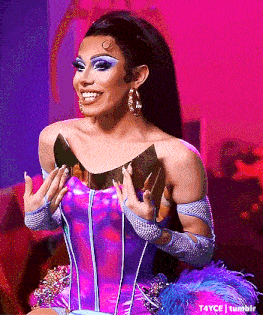 a drag queen wearing a purple corset and gloves is holding a trophy in her hands .