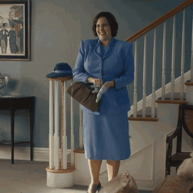 a woman in a blue suit is walking down stairs