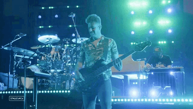a man playing a guitar in front of a stage that says stage jack