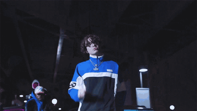 a man in a blue jacket with the letter b on the front