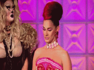 two drag queens are standing next to each other with one wearing a red top