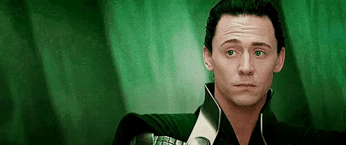a close up of a man 's face with a green background and a black shirt .