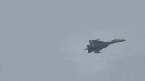 a fighter jet flying through a cloudy sky