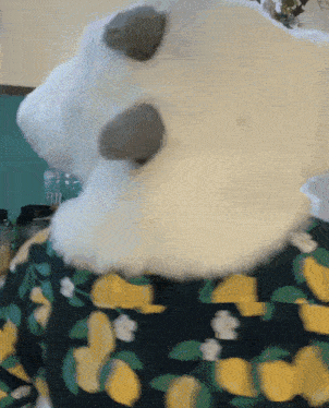 a stuffed animal is wearing a black and yellow shirt with lemons on it