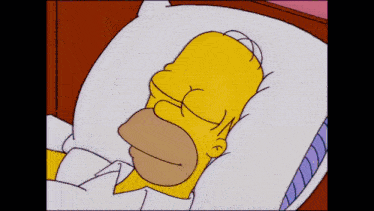 homer simpson from the simpsons is sleeping in a bed