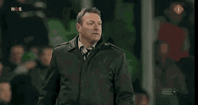 a man in a black coat giving the middle finger