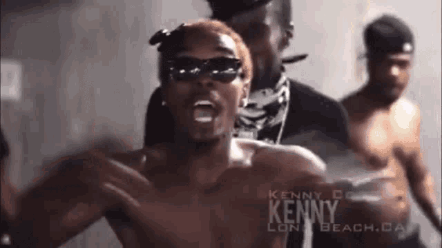 a shirtless man wearing sunglasses and a bandana with the name kenny on his chest