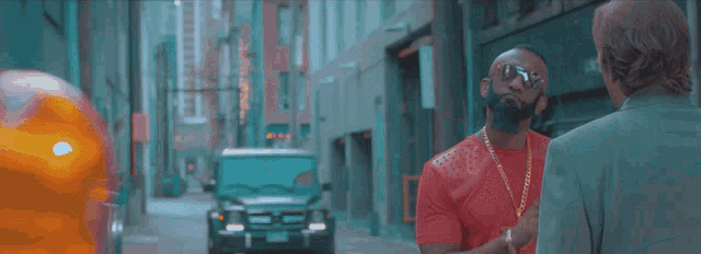 a man in a red shirt is talking to a man in a green suit