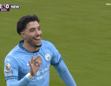 a soccer player wearing a blue etihad airways jersey celebrates a goal
