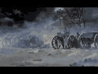 a row of cannons are lined up in a field with smoke coming out of them