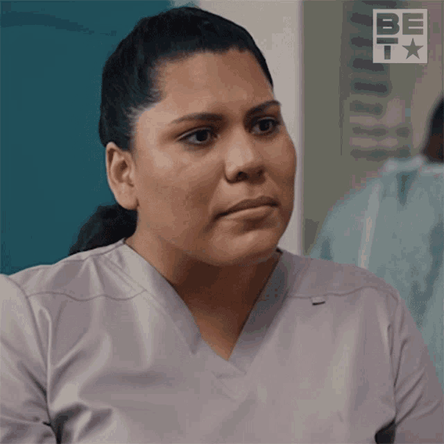 a woman wearing a scrub top with the word bet on the bottom right