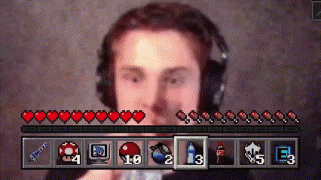 a man wearing headphones is playing a video game with hearts and items