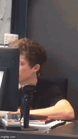 a man is sitting in front of a computer monitor .