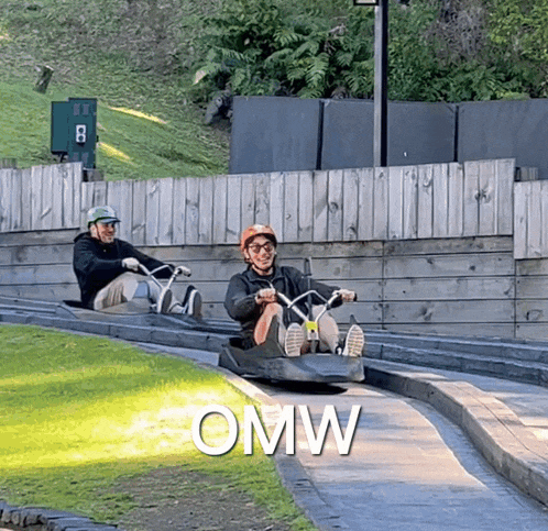 two men are sledding down a hill and the word omw is on the bottom right