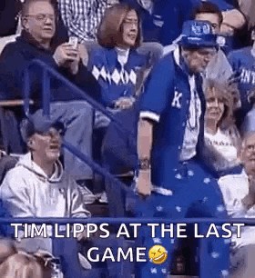 a man in a blue suit is dancing in the stands at a basketball game .