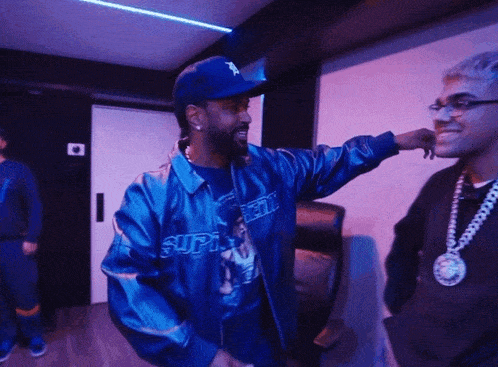 a man wearing a blue jacket that says " supreme " on it