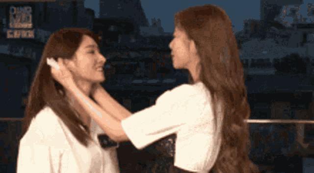 two women are touching each other 's faces in front of a sign that says dinner king