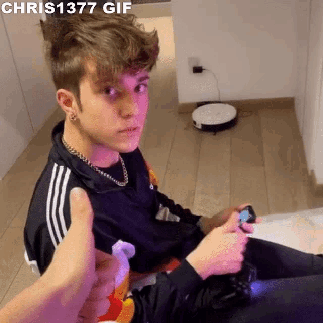 a young man is playing a video game and giving a thumbs up ..