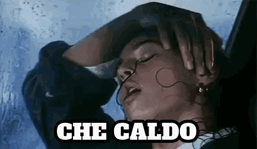 a woman is sitting in front of a window with her hand on her head and the words che caldo written on the bottom .