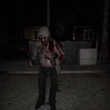 a person with blood on their clothes is standing on a sidewalk
