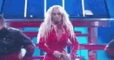a woman in a red dress is dancing on a stage with a blue background .