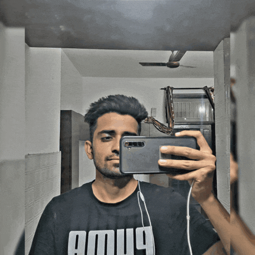 a man taking a picture of himself in a mirror with a shirt that says amug