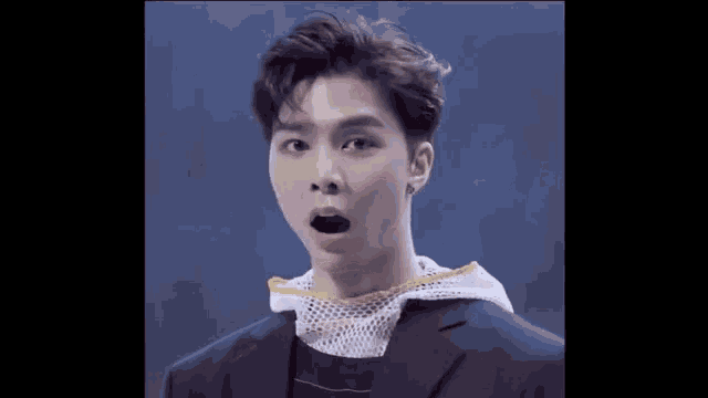 a young man in a suit is making a funny face .