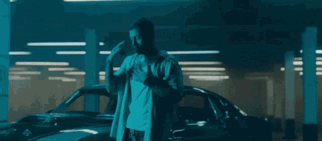 a man standing next to a car talking on a phone