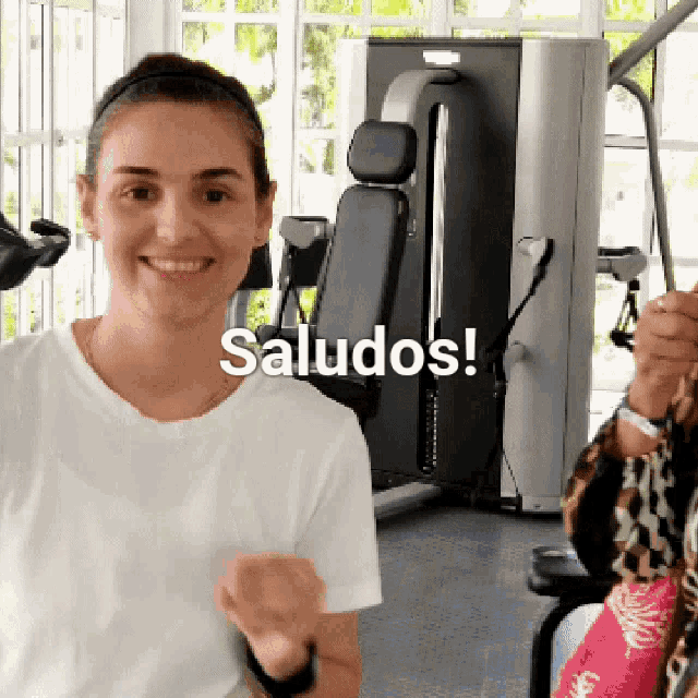 a woman is smiling in front of a machine that says saludos on it