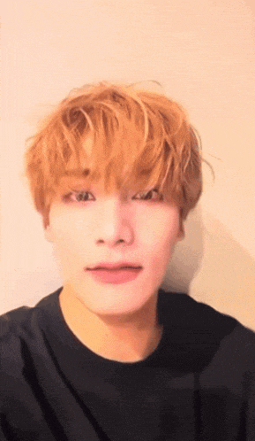 a young man with blonde hair is making a funny face