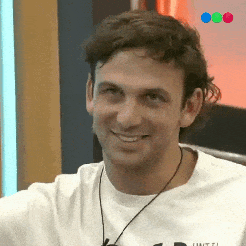 a man wearing a white shirt with the word until on it smiles