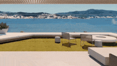 a view of the ocean from a balcony with chairs