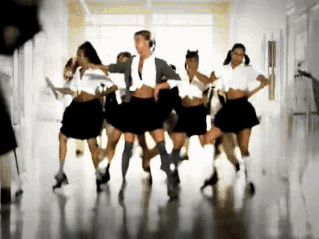 a group of women are dancing in a hallway