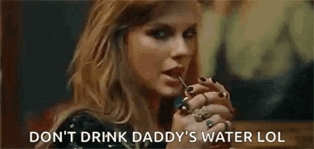 a woman with rings on her fingers is drinking water from a glass .