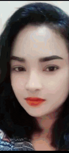 a close up of a woman 's face with dark hair and red lipstick .