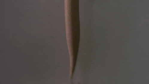 a hand is holding a cup of ice cream with a dispenser attached to it