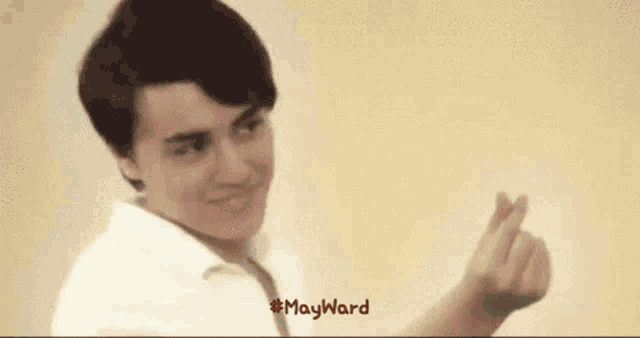 a young man is making a heart shape with his fingers and the words mayward are below him