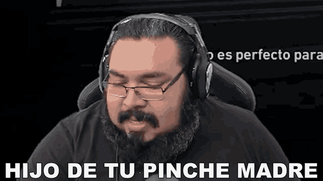 a man with glasses and a beard is wearing headphones and saying hijo de tu pinche madre .