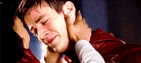 a close up of a person touching a man 's face with their hand .